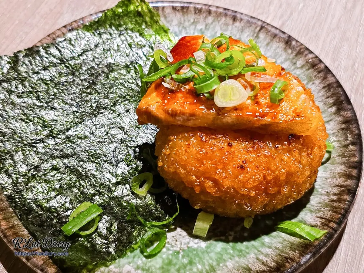 山鯨燒肉鮭魚起司飯糰近照，展現頂層鮭魚油脂與下方飯糰金黃鍋巴
