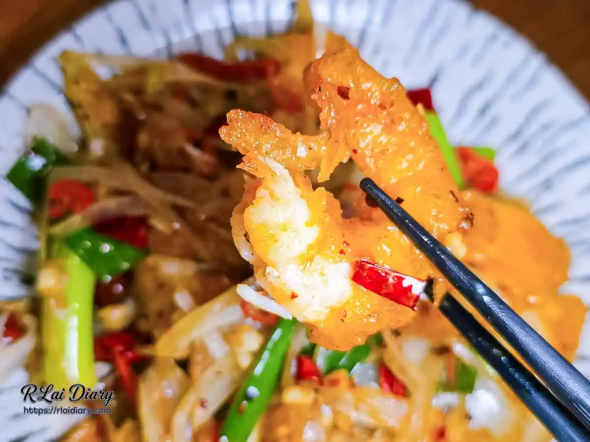 夾起椒麻檸檬蝦球的斷面秀，顯示輕薄酥脆麵衣與飽滿彈牙的蝦肉