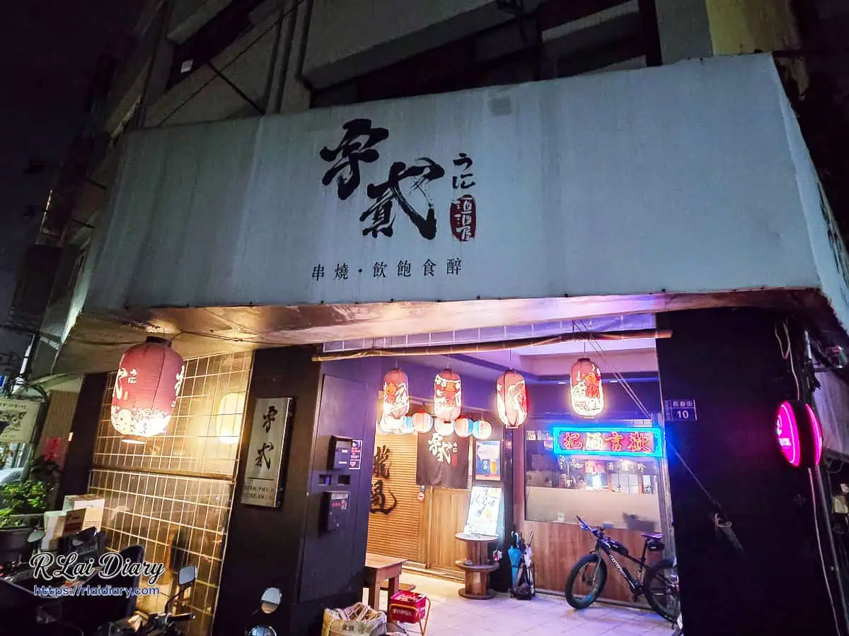 台中西區宇貳居酒屋店面外觀，夜晚紅色燈籠與把酒言歡霓虹燈招牌