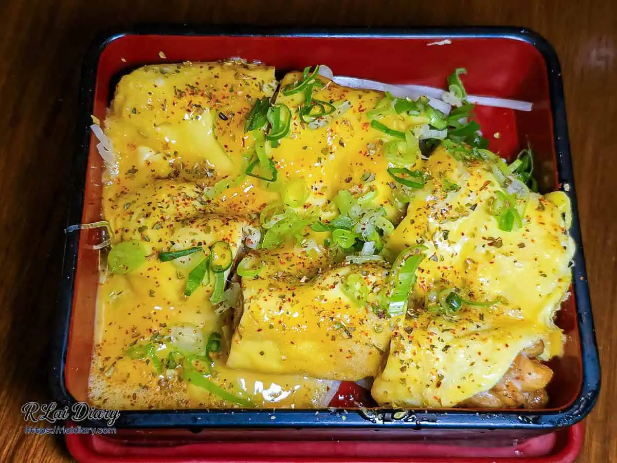 宇貳居酒屋特色料理滑蛋烤雞，盛裝在日式方盒中的金黃滑蛋料理