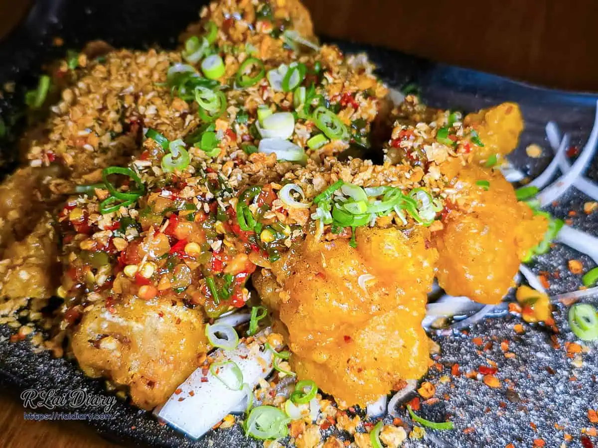 宇貳椒麻雞特寫，酥脆麵衣上鋪滿辛香料與蒜酥的豐富層次