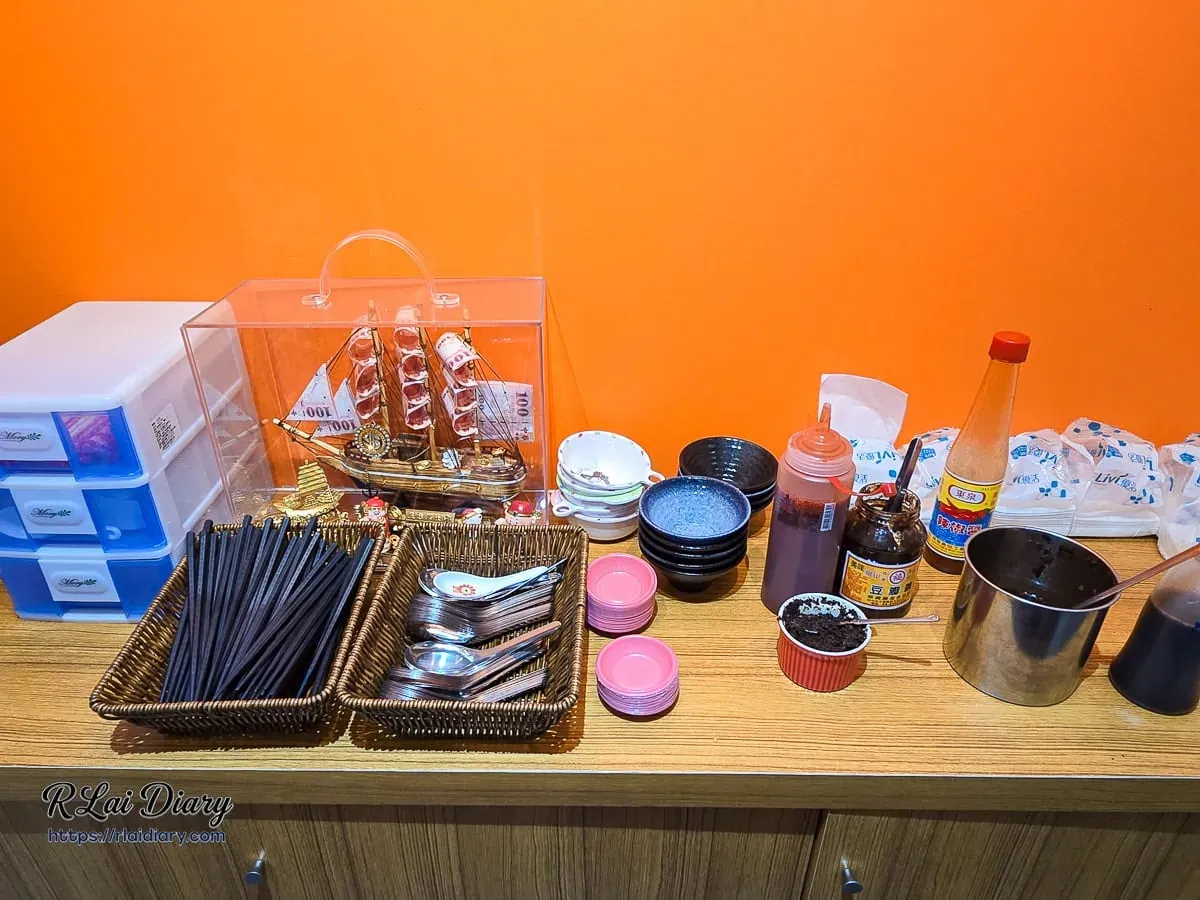 鹿港圓環頂漢口店自助醬料與餐具區，橘色背景牆展現明亮暖色調空間