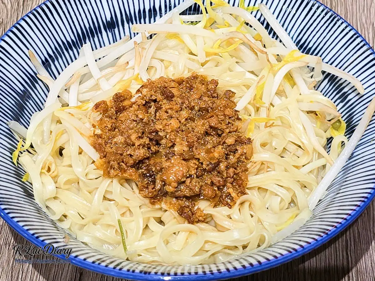 乾意麵側面特寫，波浪狀麵體掛滿醬汁的誘人視覺