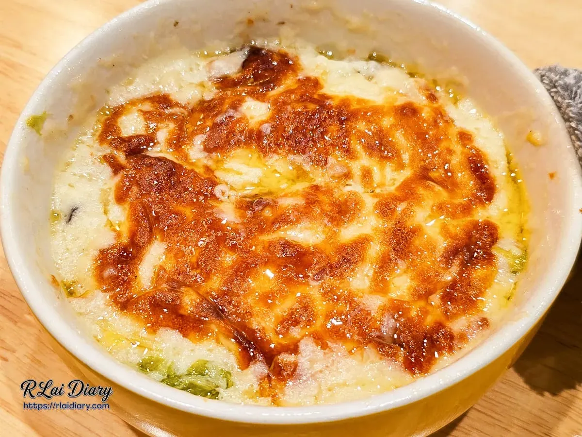奶油焗白菜表面起司烘烤至微焦金黃，散發濃郁乳香與焦甜味