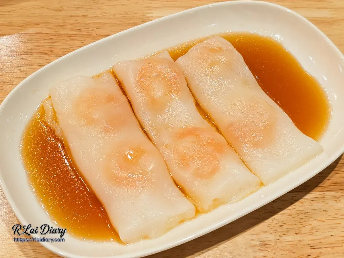 經典蝦仁腸粉，薄透粉皮包裹著大顆鮮蝦，浸潤在特製鹹甜醬汁中