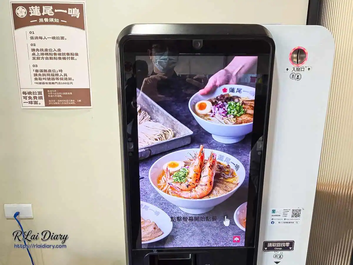 蓮尾一鳴直立式自動點餐機，螢幕正顯示著招牌甘海老王樣拉麵的誘人實品照片