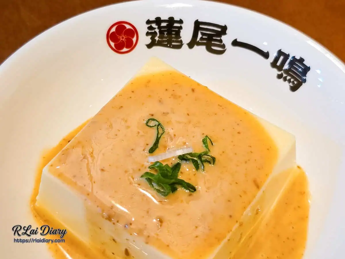 蓮尾一鳴和風豆腐近拍特寫，細膩的焙煎芝麻醬汁表面點綴著極具巧思的翠綠蔥絲