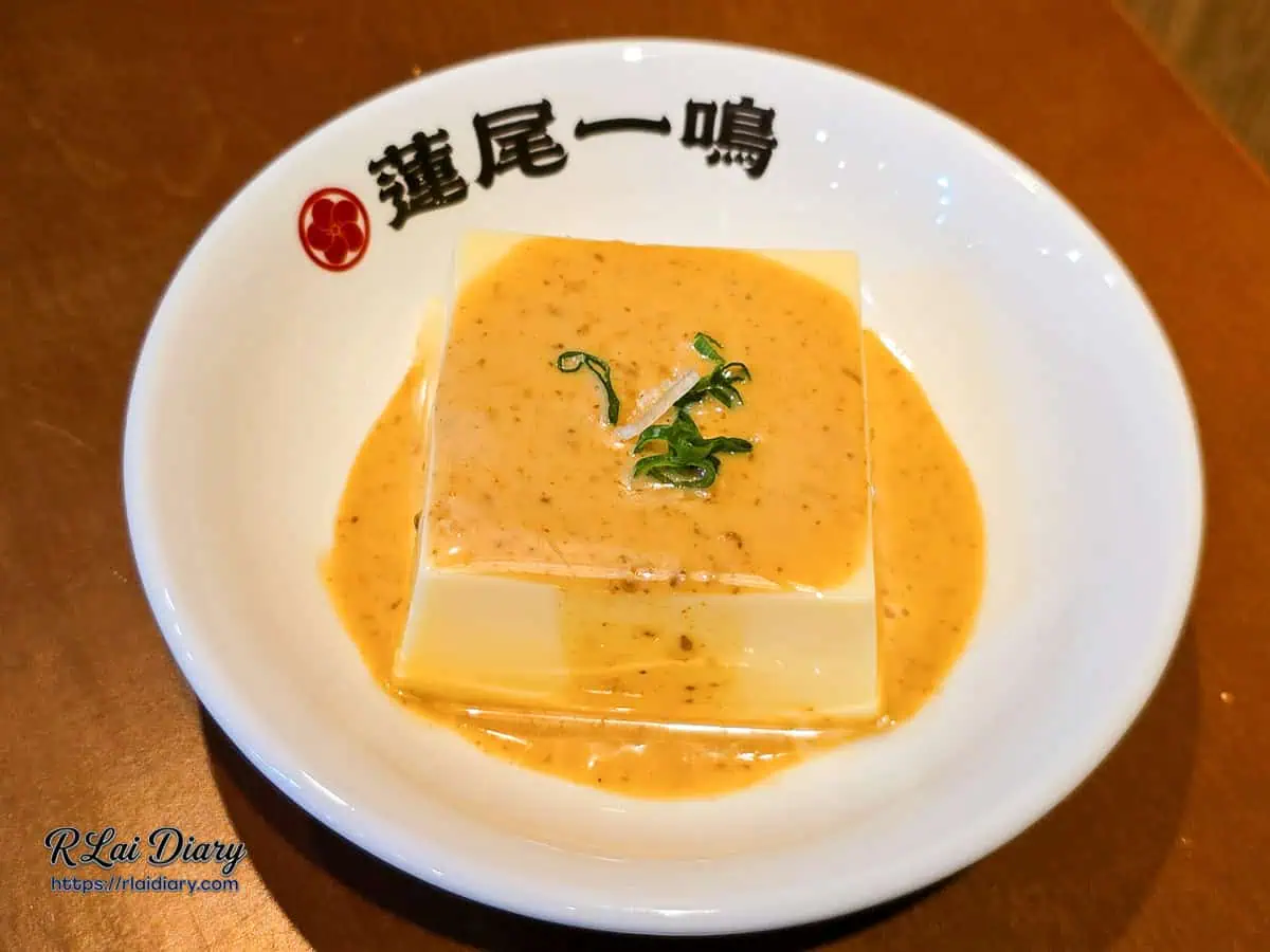 蓮尾一鳴開胃小菜和風豆腐全貌，純白方正的豆腐豪邁淋上特調胡麻醬，以白瓷盤高雅盛裝