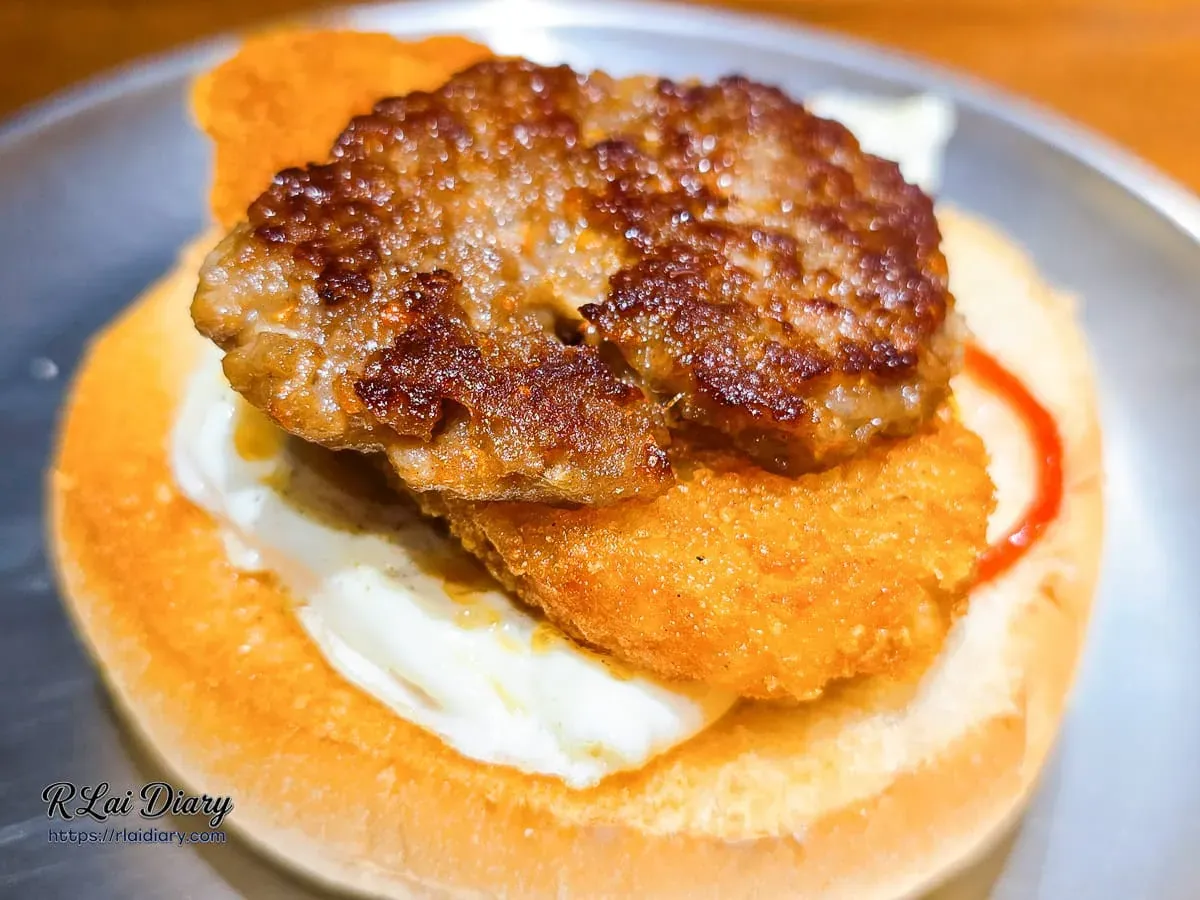 白暮漢堡內層厚實肉排疊加金黃酥脆薯餅特寫