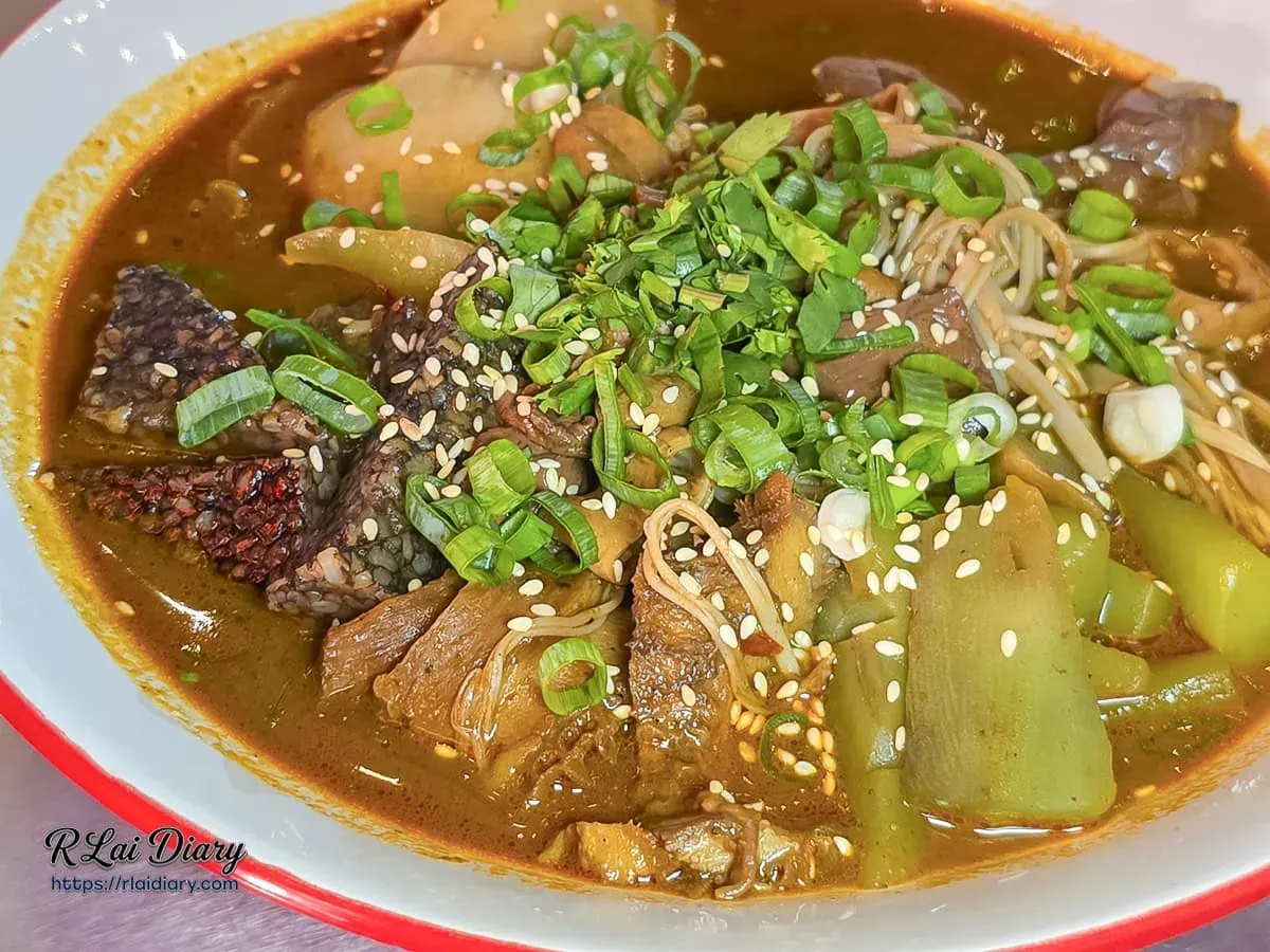 玖樓重慶麻辣燙配料特寫，香麻湯底撒滿翠綠蔥花與白芝麻，交織著軟糯米血與鮮甜時蔬
