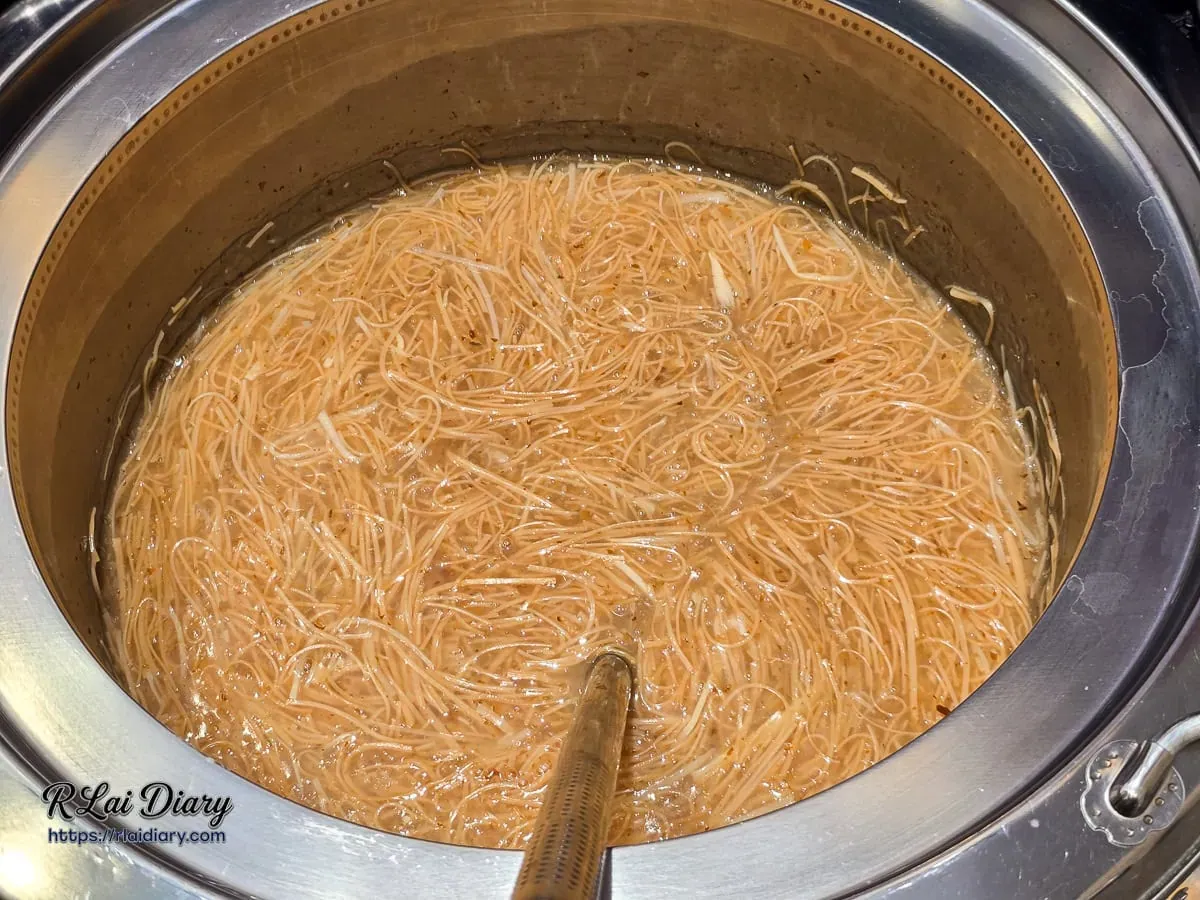 大圓鍋內正翻滾著的琥珀色手工麵線與柴魚湯底特寫