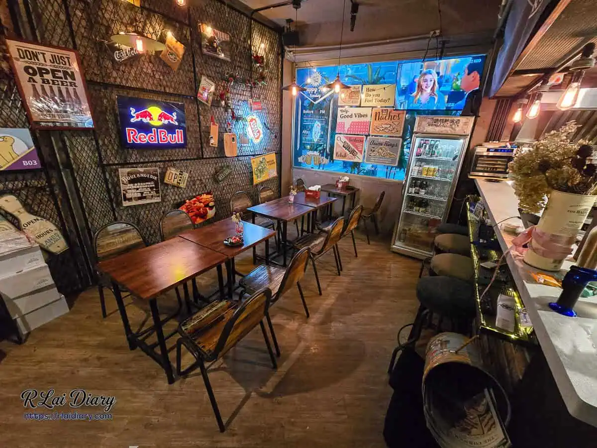 角窩一樓室內用餐區，牆面佈滿美式復古廣告牌與運動酒吧氛圍