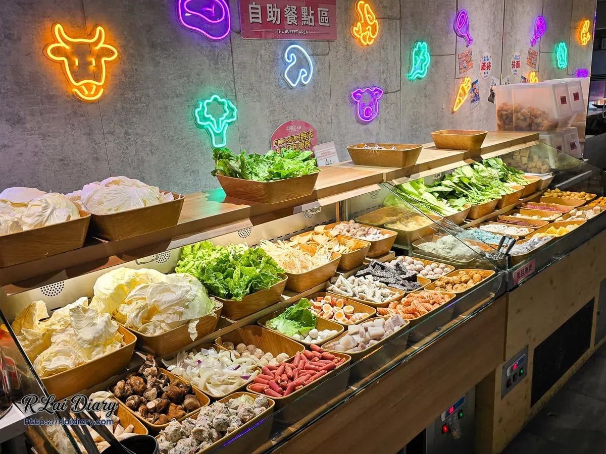 自助餐點區全景，彩色霓虹造型燈飾與豐富的蔬食吧