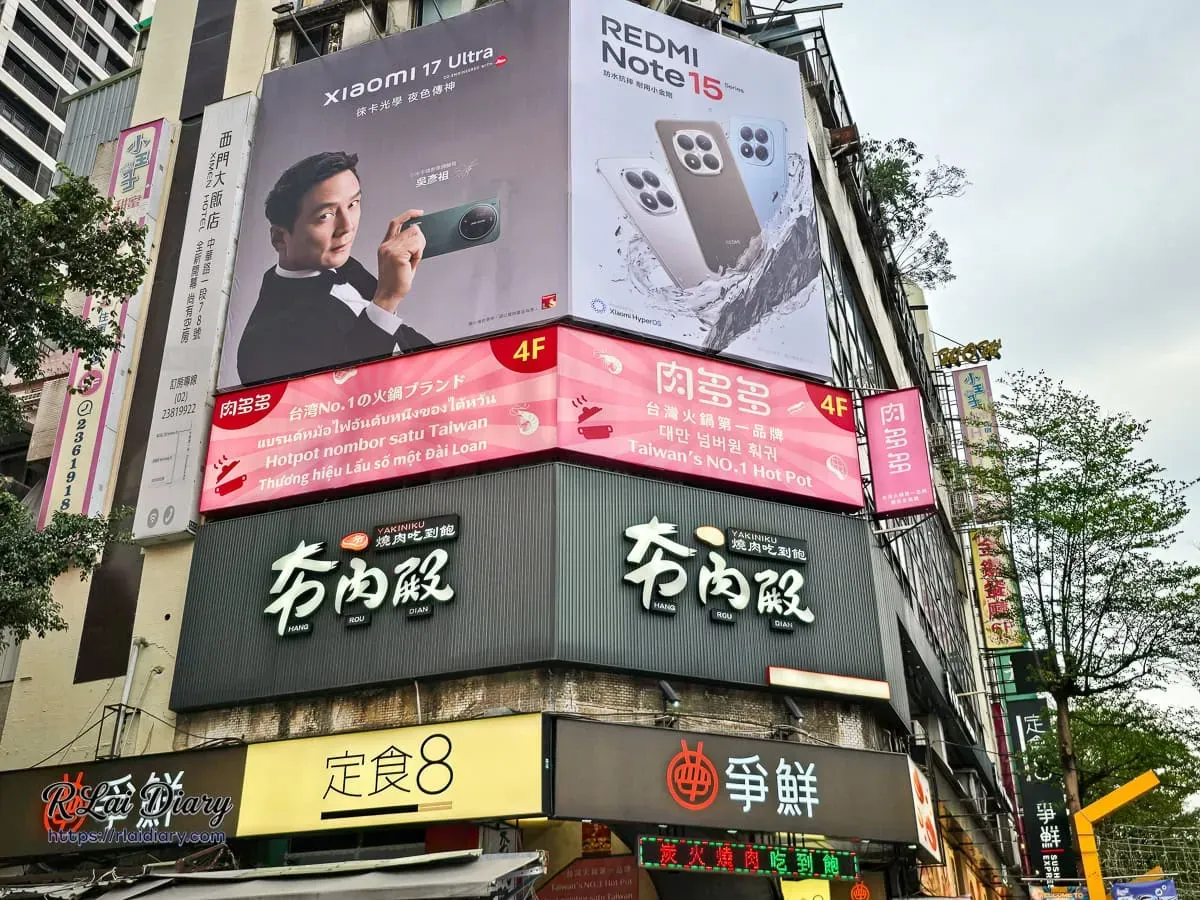肉多多火鍋台北西門店外觀，顯眼的粉紅色廣告招牌與西門町漢中街景