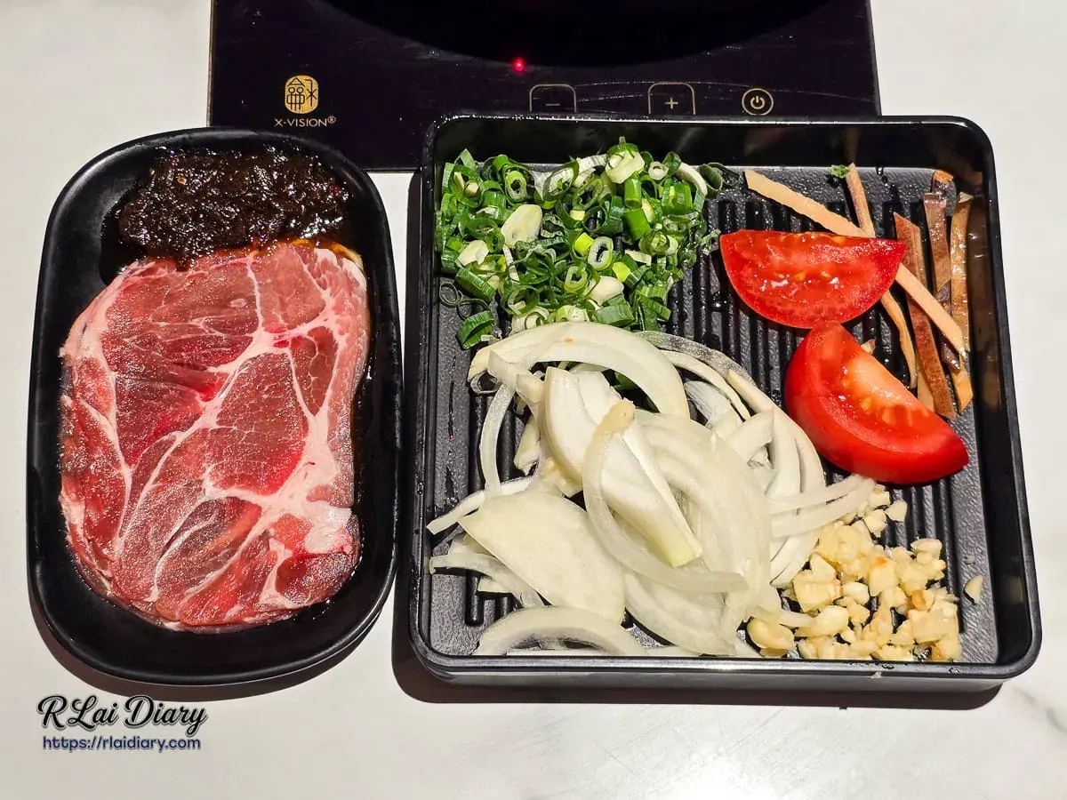 爆炒石頭鍋底配料盤，包含梅花豬肉片、洋蔥、蒜末、蔥花與番茄