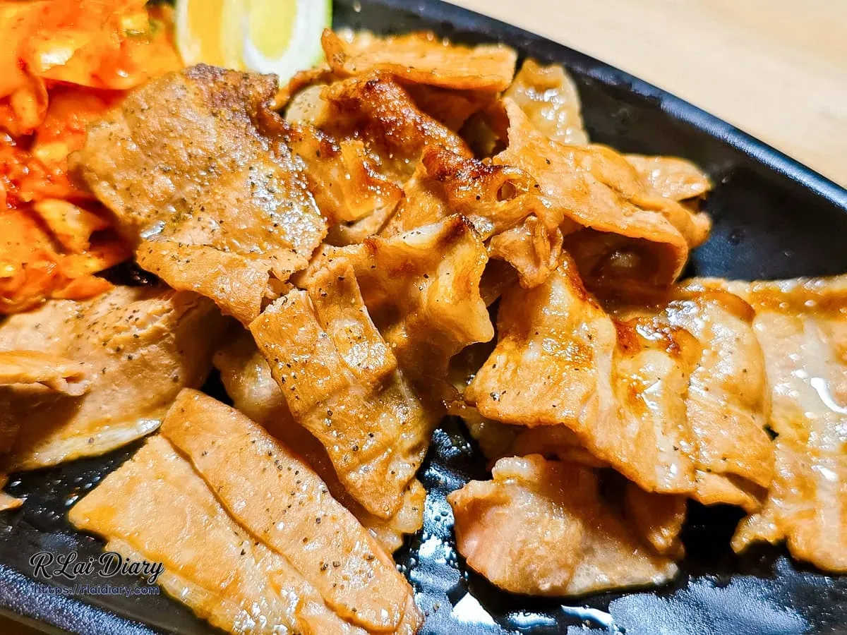 帶著微焦脂香與黑胡椒香氣的炭烤豬五花肉片特寫