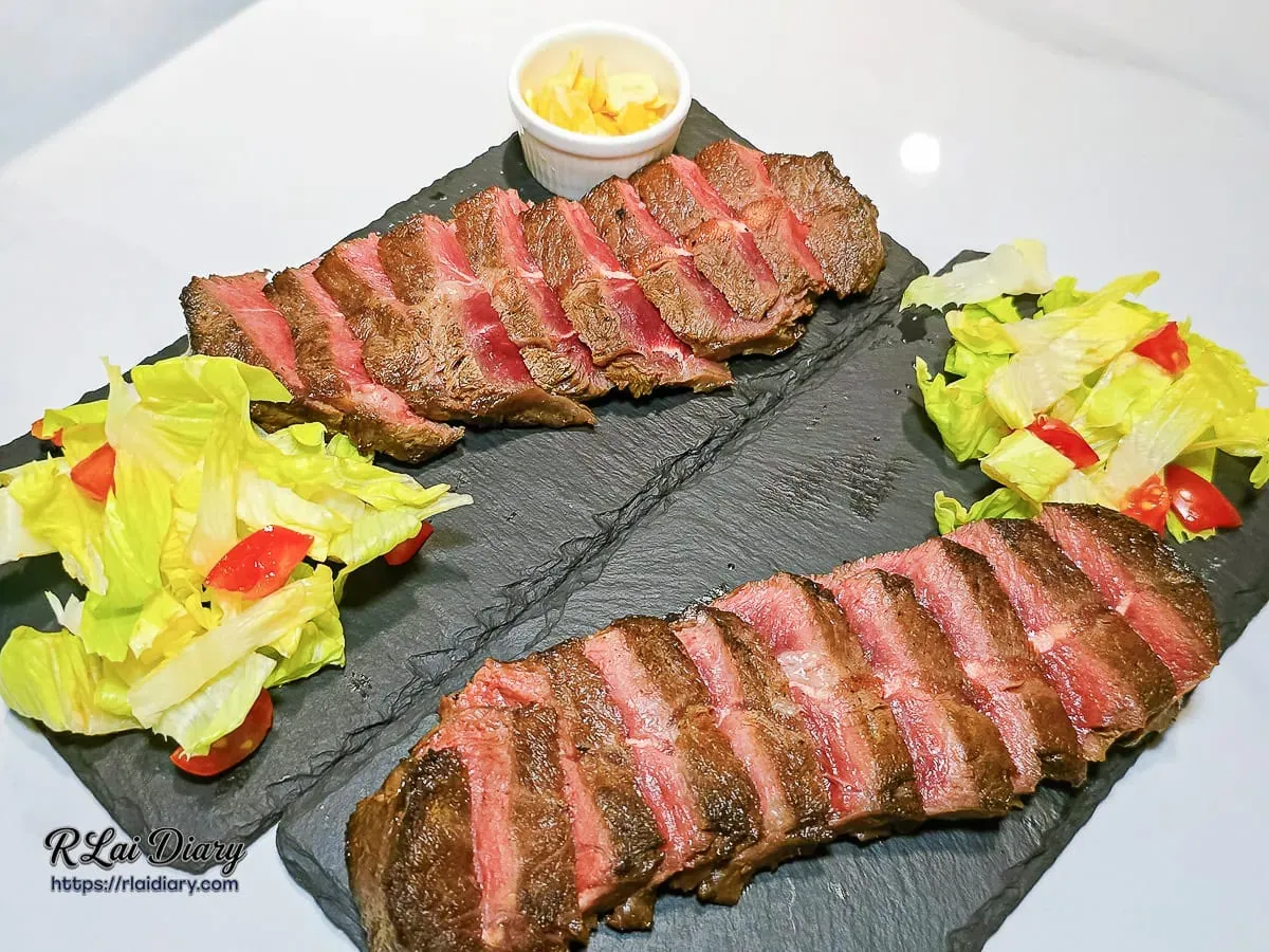 舒肥嫩肩牛排套餐，附上酥脆蒜片與清爽生菜沙拉，週四限定買一送一優惠
