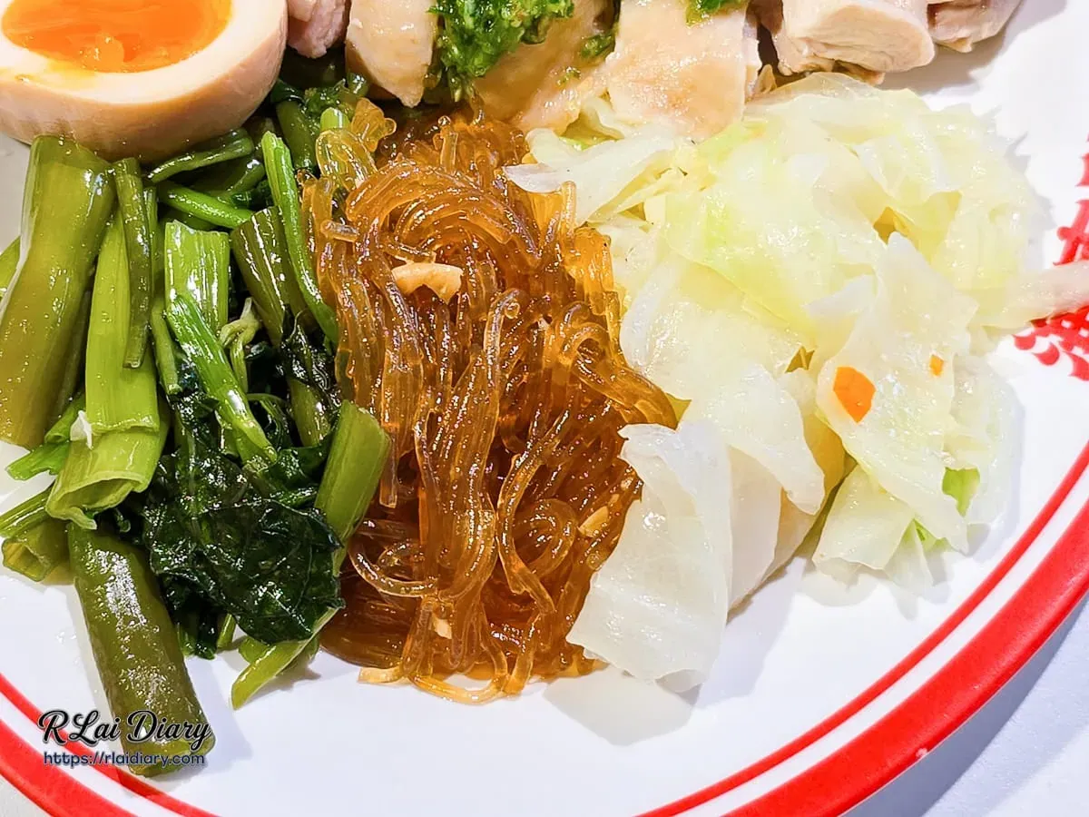 海南雞飯豐富配菜特寫：包含清脆時蔬、粉絲與琥珀溏心蛋