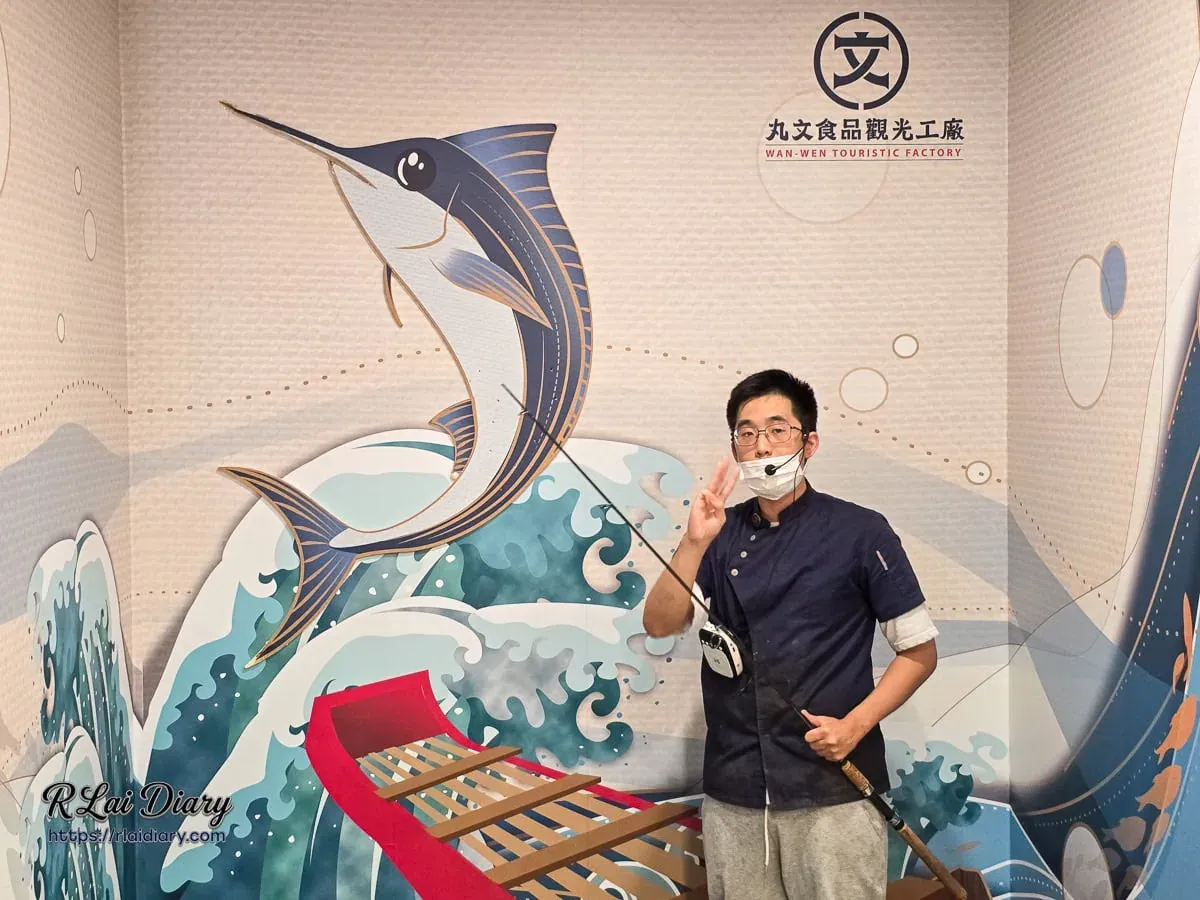 導覽員示範互動拍照牆，模擬海上釣旗魚的趣味場景