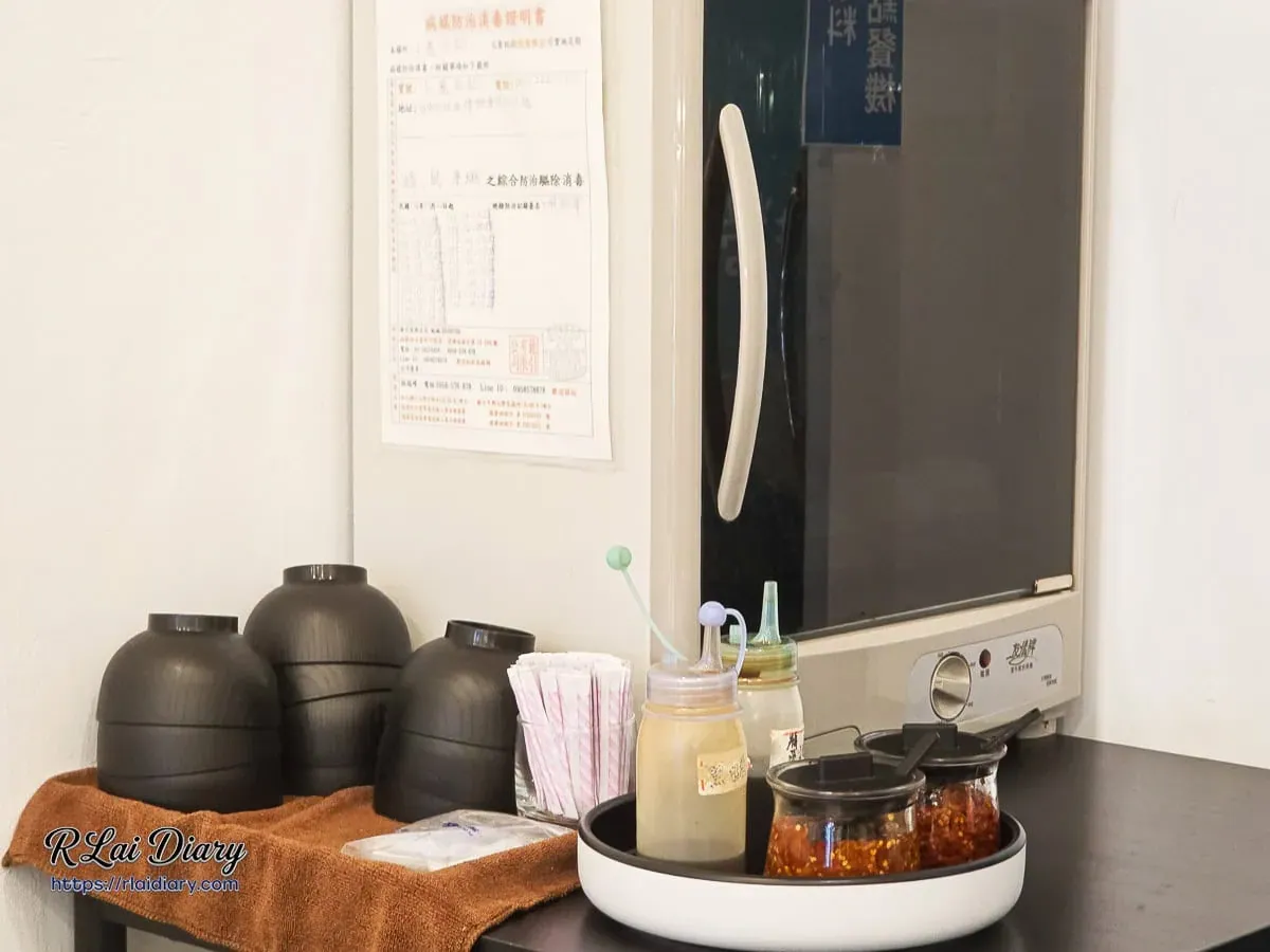 小捲日記自助區整齊黑色餐具與特製麻辣牛油醬料罐