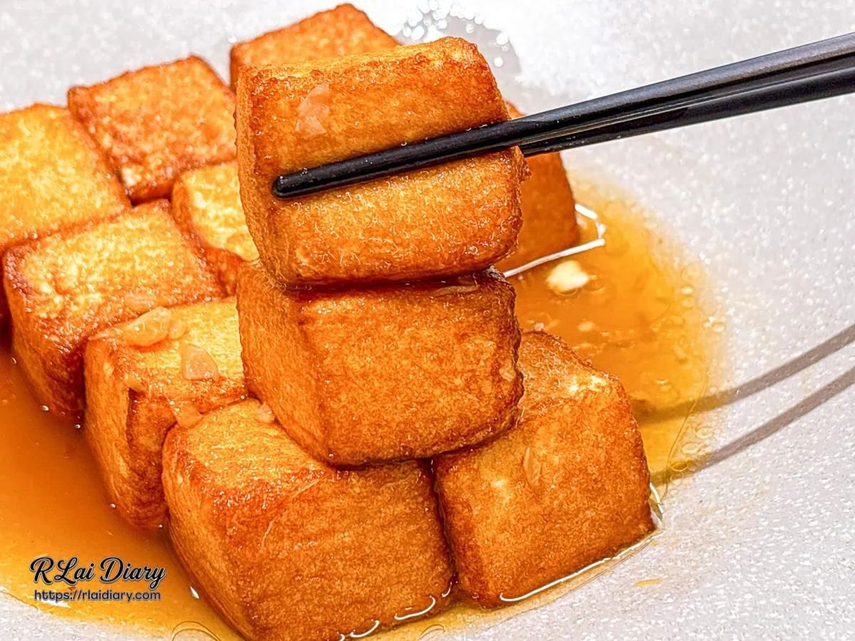 用筷子夾起 GOGOGA 外酥內嫩的老皮嫩肉豆腐