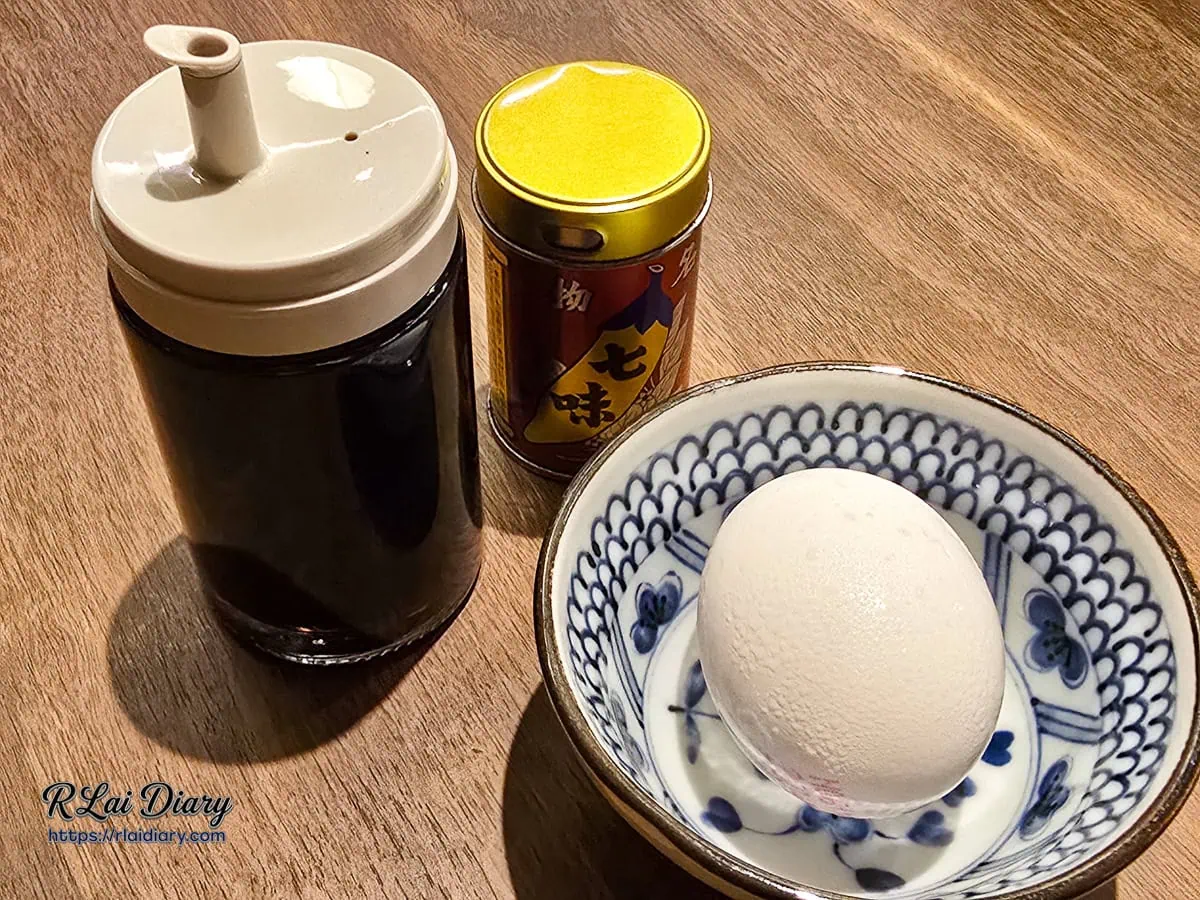 東山定食附贈的生食級雞蛋，搭配桌上日式特製醬油與七味粉