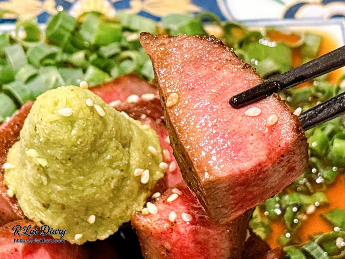 夾起東山山葵厚切牛舌特寫，肉汁飽滿且呈現誘人玫瑰色澤