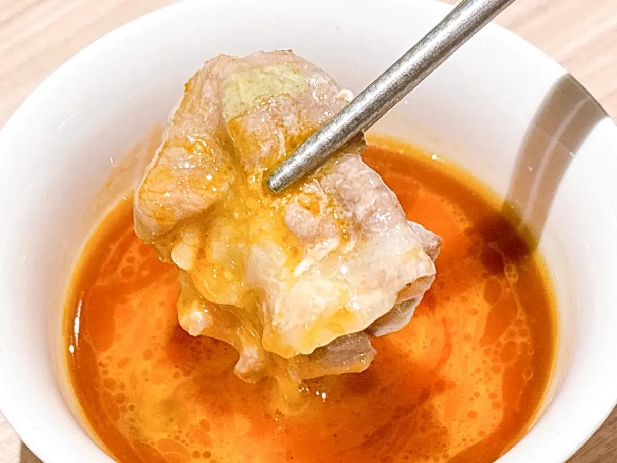 涮熟豬肉沾取蛋黃沙茶醬，口感滑順濃郁的終極美味