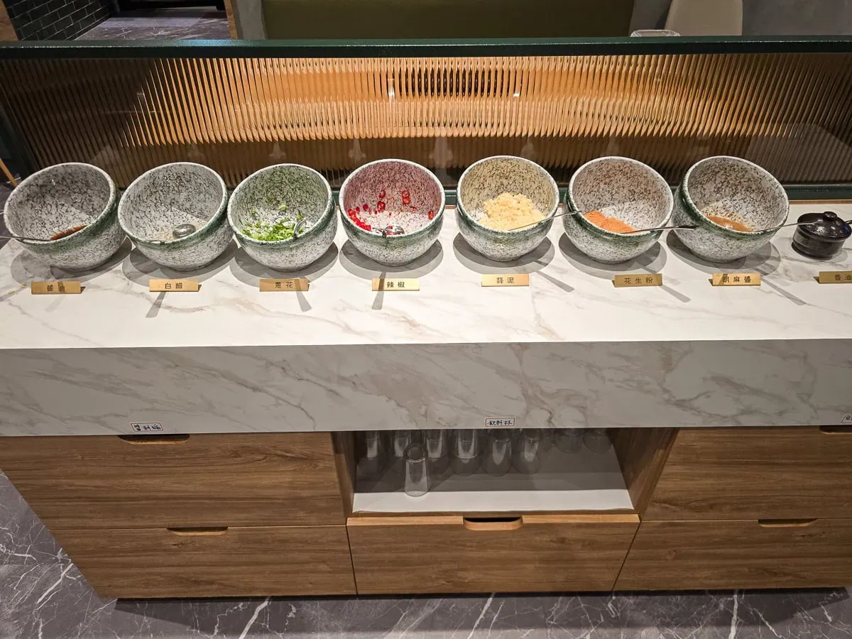 老沙茶醬料自助區，提供新鮮蔥花、辣椒與特製沙茶醬