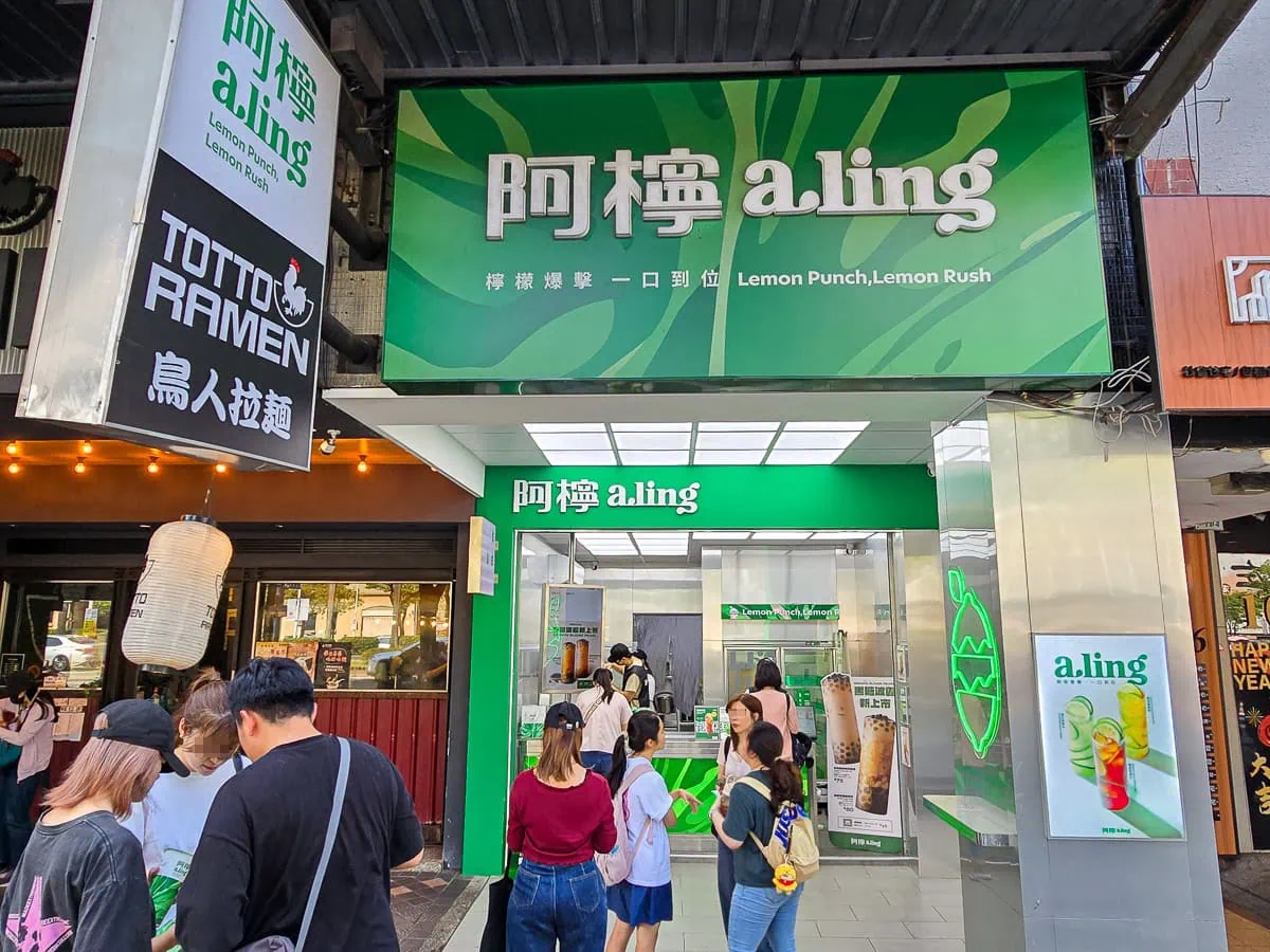 位於捷運西門站附近的阿檸a.ling西門鮮檸所門市外觀，不鏽鋼與品牌綠交織的現代極簡店面