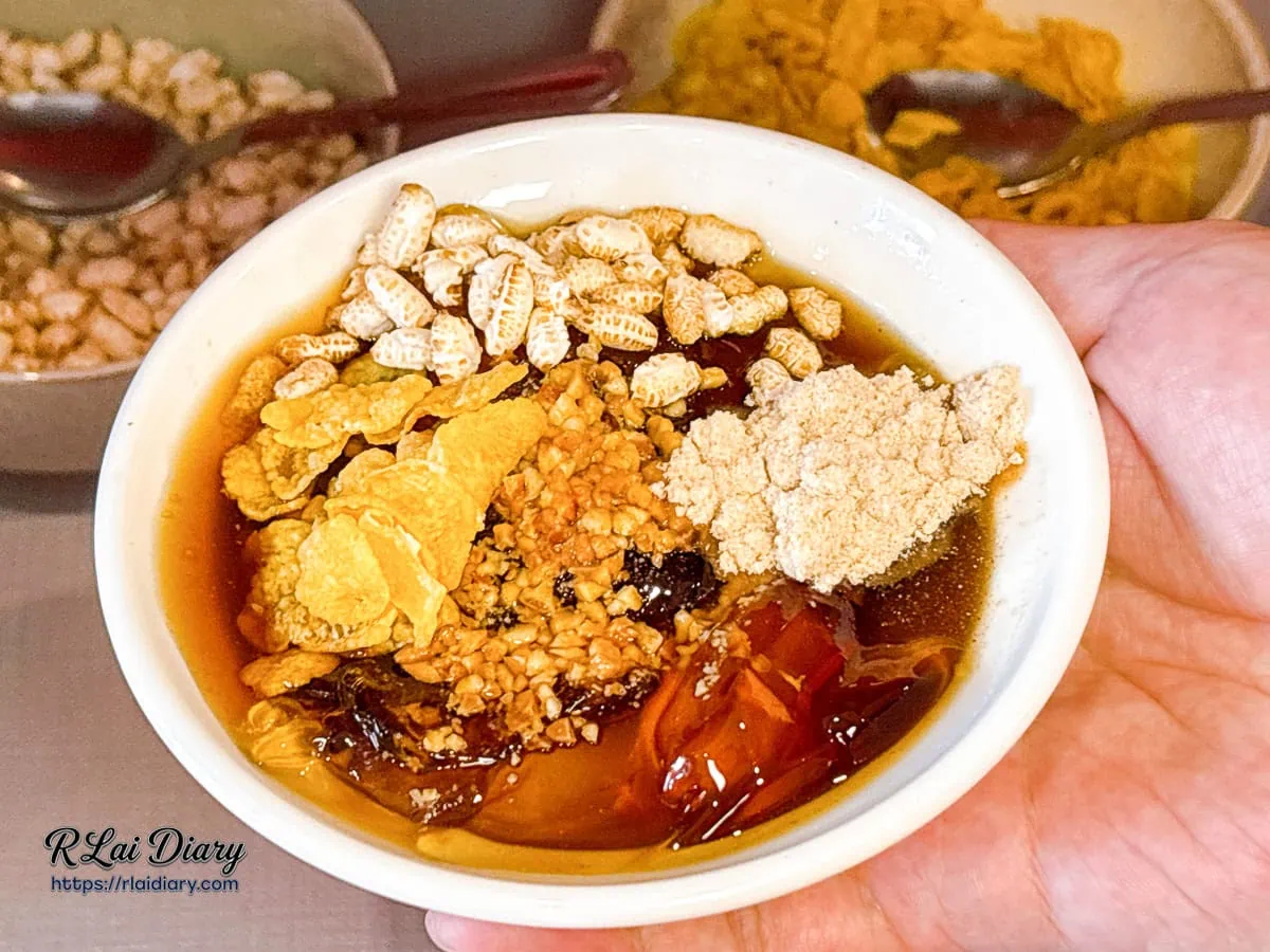 手捧配料豐富的DIY重慶甜冰粉，鋪滿米香與玉米脆片