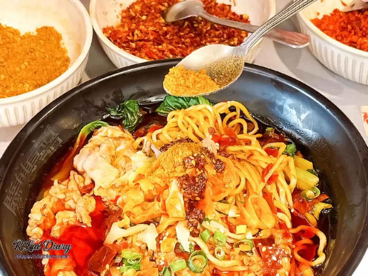 老饕吃法：使用湯匙為重慶小麵額外灑上特製麻辣粉