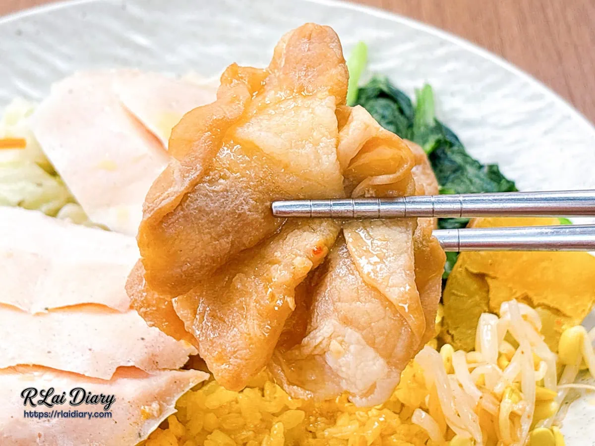 用筷子夾起有飯食光油脂比例完美、微甜入味的特製醬燒豬梅花肉片