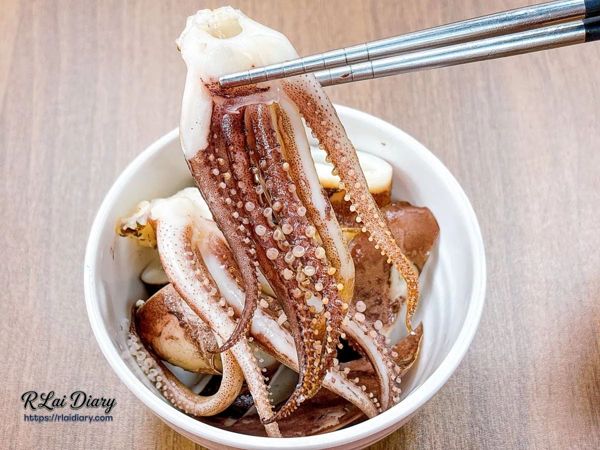 用筷子夾起有飯食光份量澎湃炸出、肉質緊致脆彈的原味汆燙深海魷魚觸鬚
