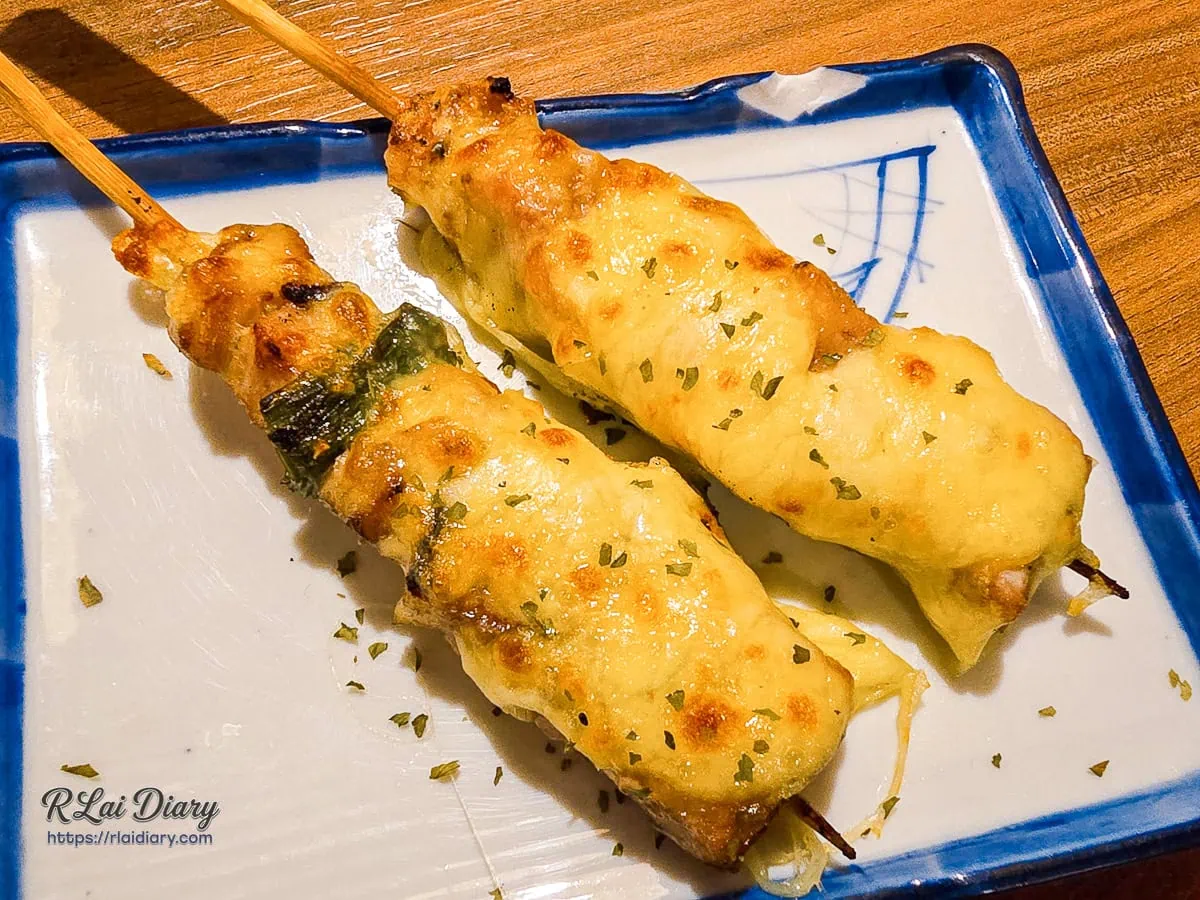 純炭火生烤起司雞肉蔥兩串撒上香草碎且油脂豐厚的邪惡牽絲串燒