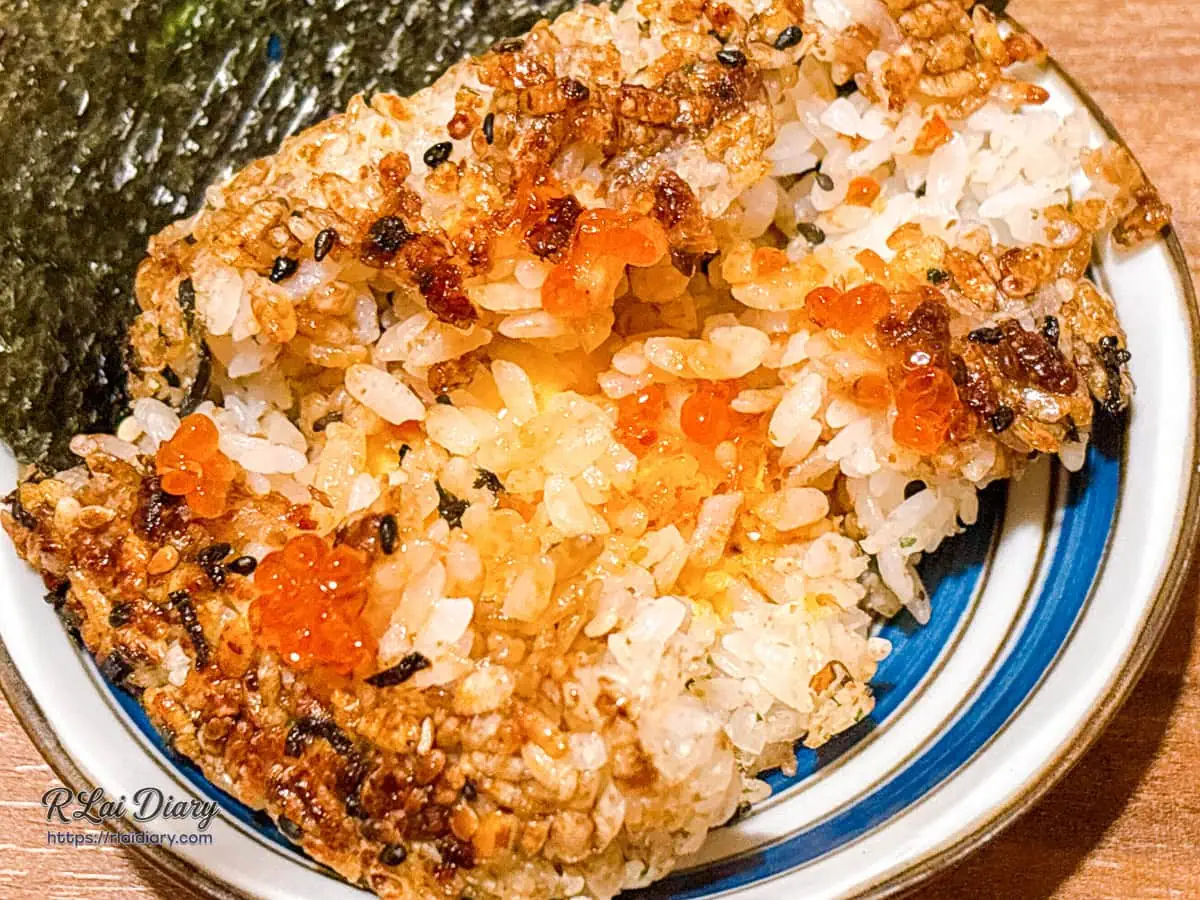 乳酪鮭魚烤飯糰三角形撥開斷面內裡流淌出金黃色溫熱起司乳酪與細緻鮭魚肉