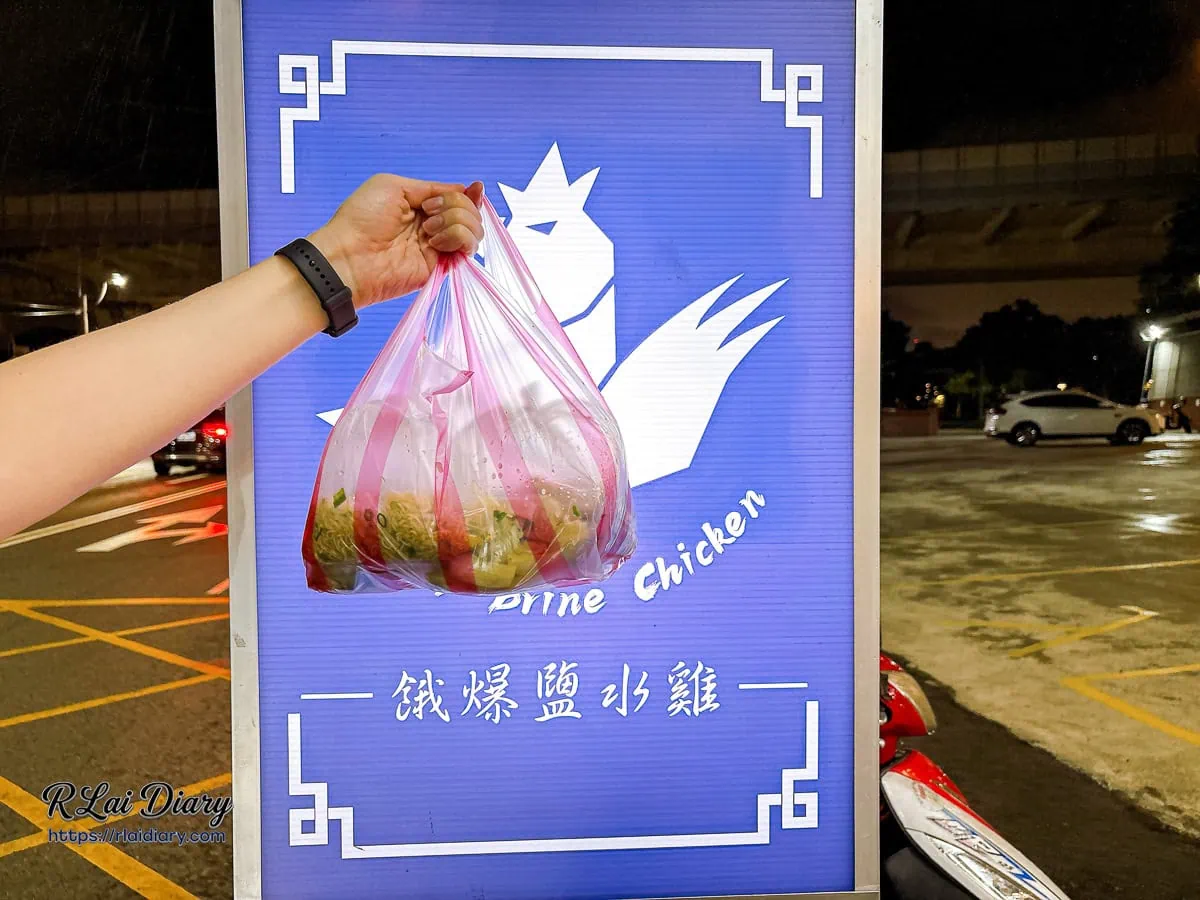 夜晚溪洲西路上提著餓爆鹽水雞外帶提袋與寶藍色招牌的深夜打卡