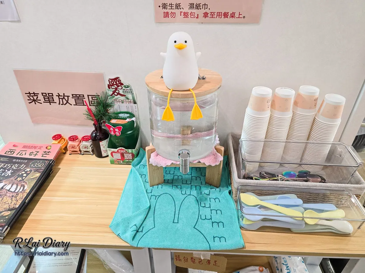 敲敲雪冰舖自助區，設有可愛療癒的鴨子造型飲水桶與彩色餐具，充滿巧思的店內細節