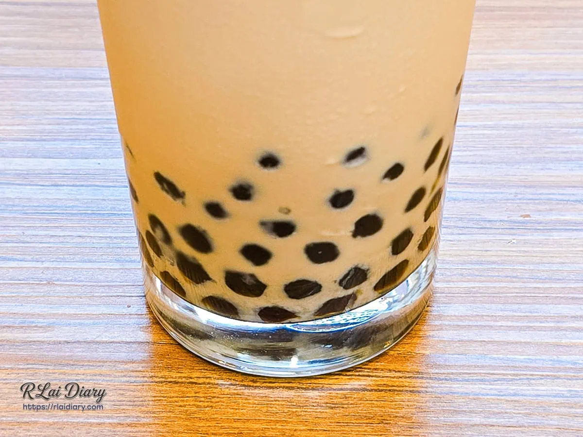 靜靜沉澱在三月春焙烏龍奶茶杯底的手工黑糖珍珠，折射出晶瑩絲絨光澤，為厚實茶湯托襯出Q彈的焦糖甜意
