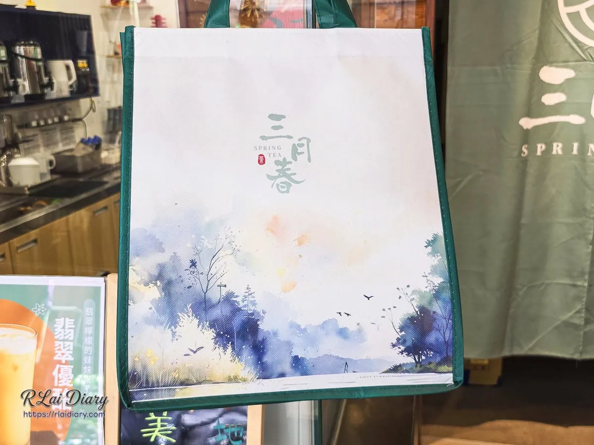三月春品牌專屬不織布提袋，表面渲染著藍紫迷霧與山水潑墨美學，將外帶手搖飲化作帶得走的流動美學