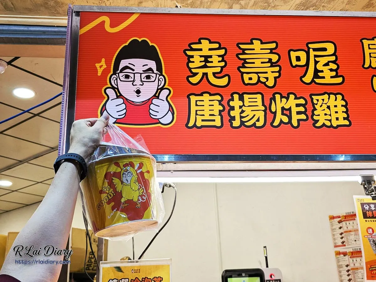 舉起堯壽喔奇蹟桶與台中太原店鮮橘色招牌合影，人氣打卡炸雞店