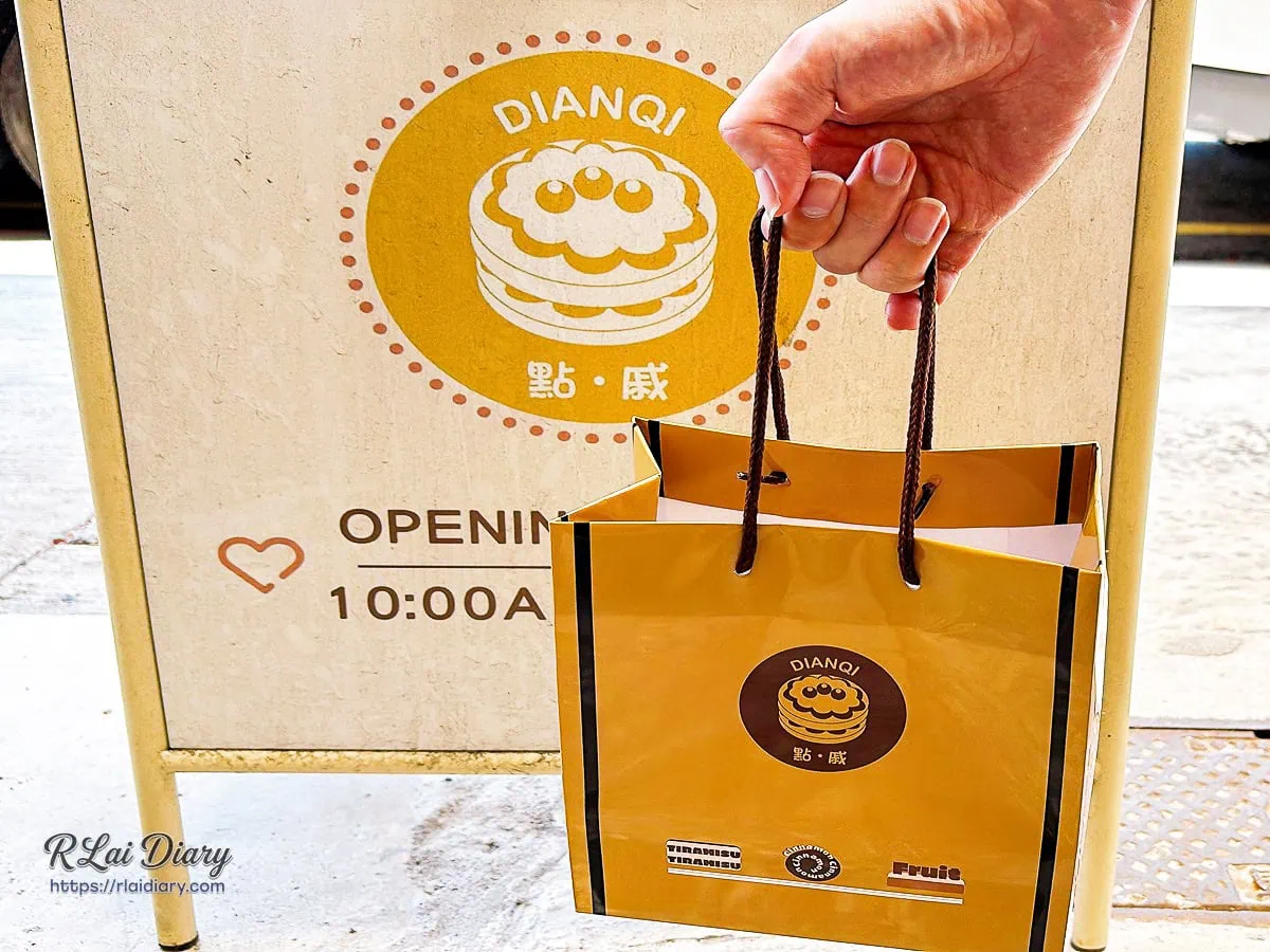 手提點戚DIANQI精美皮質紙袋於店門口立牌合影