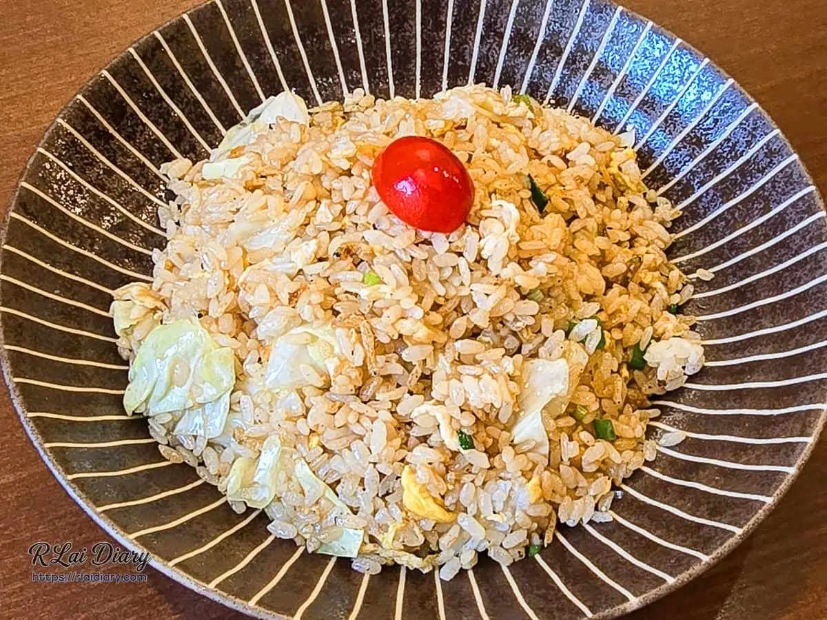精緻日系深盤盛裝的酥魚炒飯，頂部點綴醃漬紅茄，台中北屯高評價創意炒飯主食
