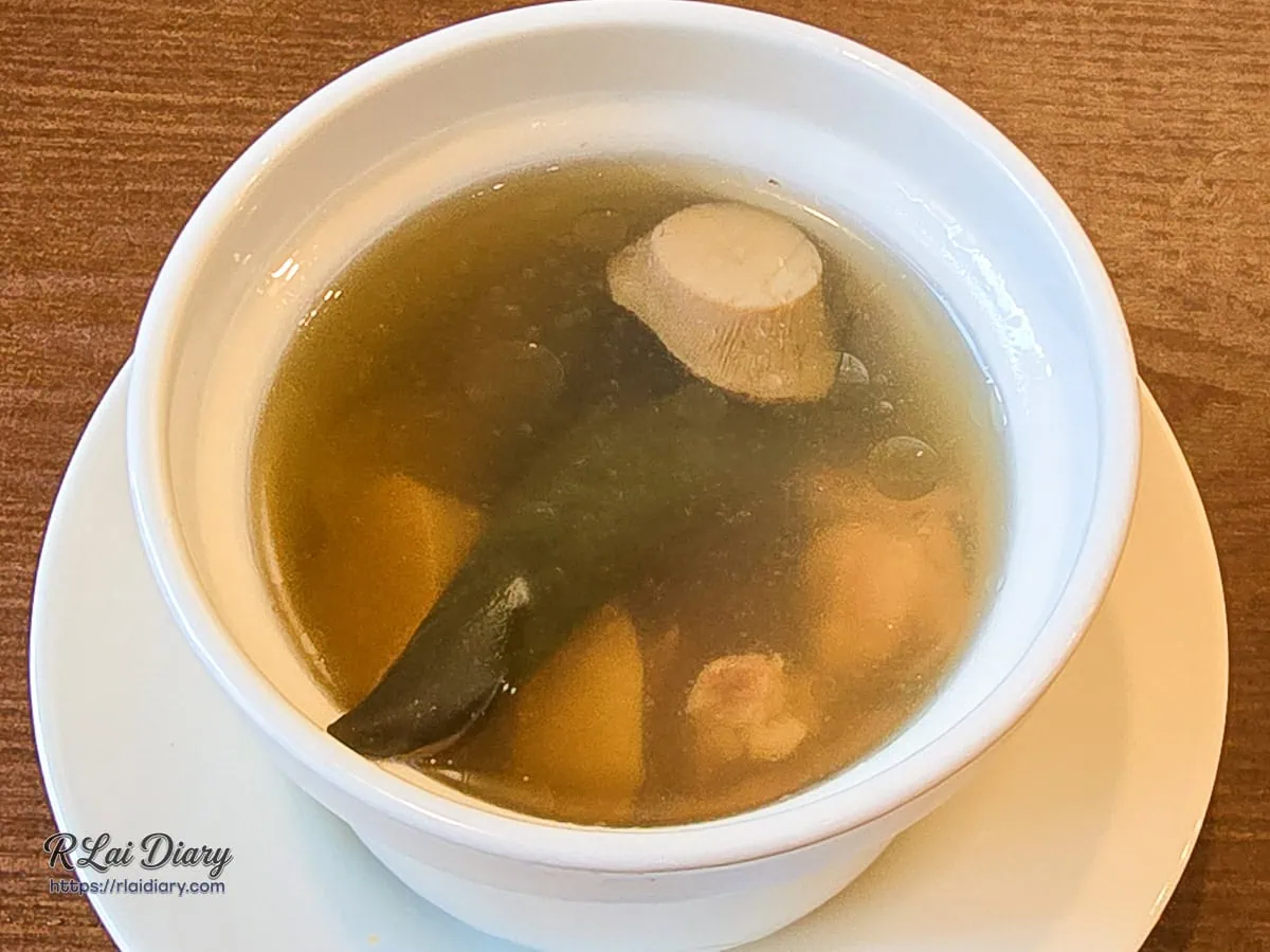 盛裝在純白湯盅裡的每日例湯剝皮辣椒雞湯，湯頭清澈澄透、風味鮮甜甘美暖胃