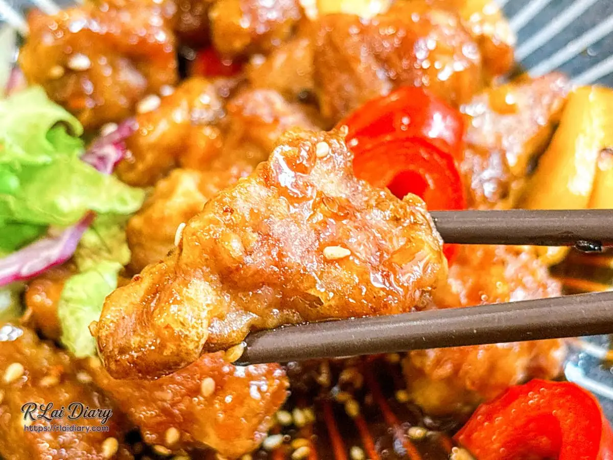 創意私房火候菜「麥芽糖牛肉」筷子夾起特寫，軟嫩肉片裹滿琥珀色晶瑩麥芽醬汁