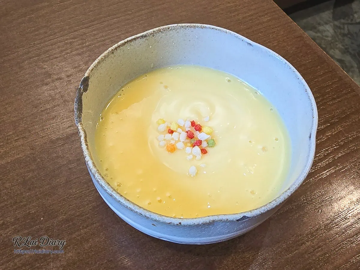橙蜜金纏蝦隨盤特製醬料特寫，細滑澄黃色果香乳化質地，頂部撒上繽紛彩糖晶粒