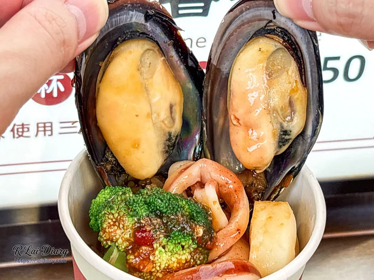 冠顗油飯一中店蒜香海鮮油飯丼，鋪上新鮮肥美的帶殼淡菜與特製蒜蓉醬汁