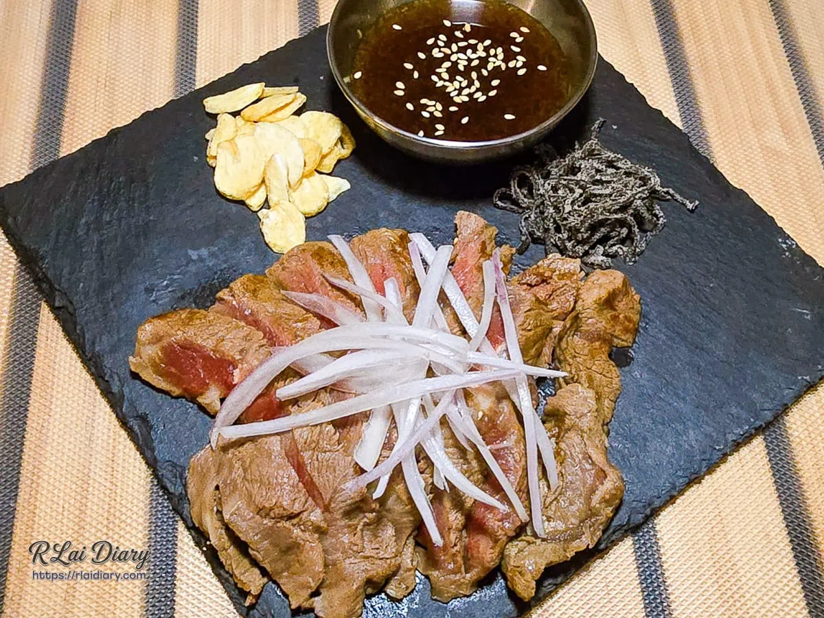 稷旬蒔堂居酒屋粉嫩色澤的和風炙燒牛排鋪滿清爽紫洋蔥絲
