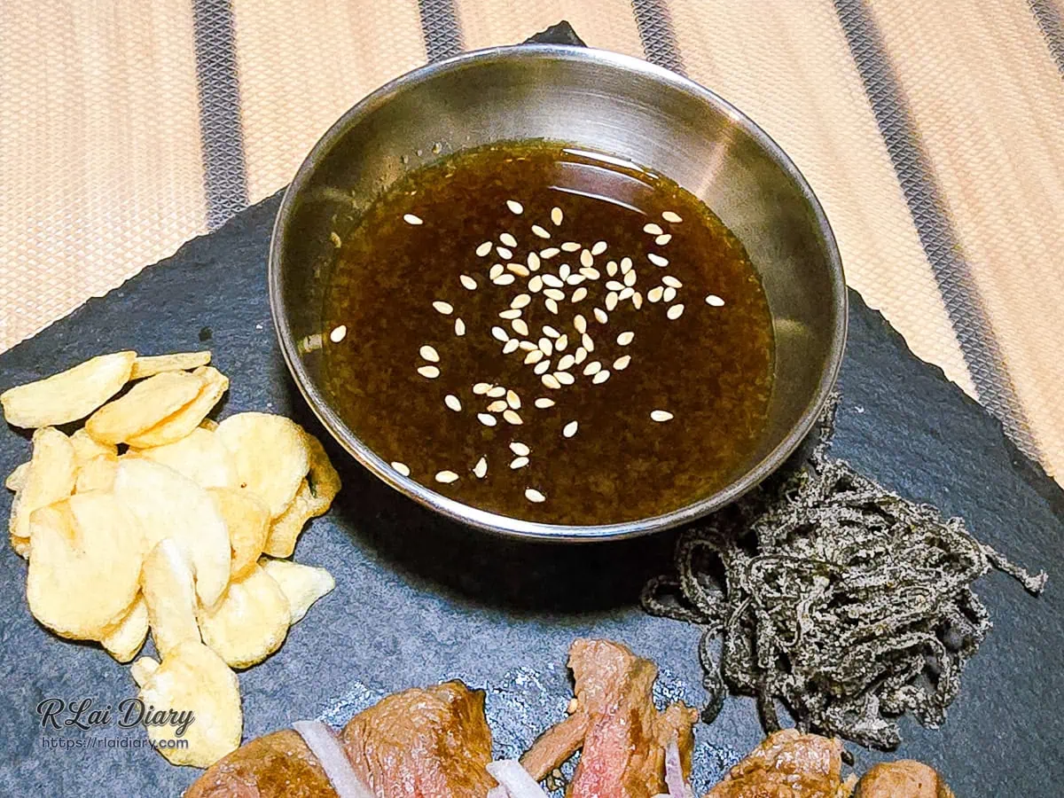 稷旬蒔堂居酒屋岩板盛裝的軟嫩和風炙燒牛排與酥脆炸蒜片